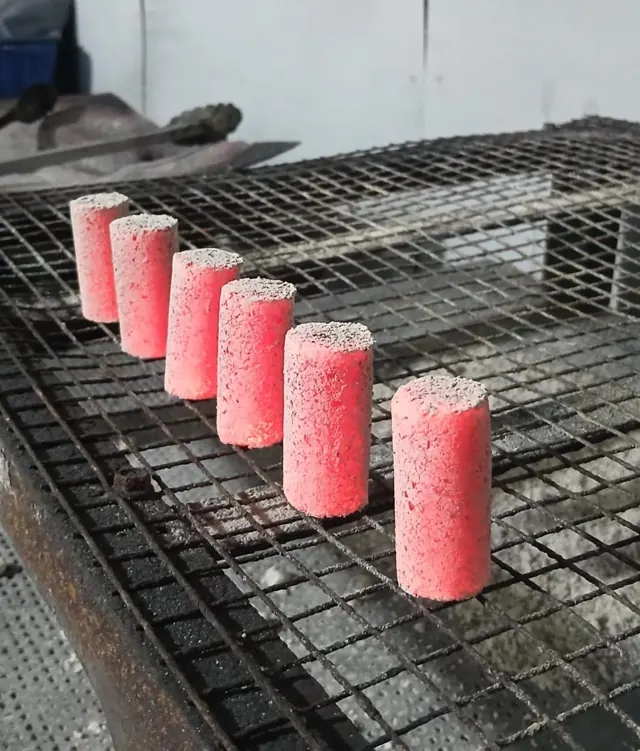 Finger-stick coconut charcoal briquettes during a burn test